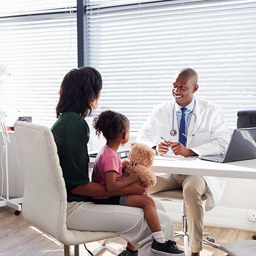 Link to our Family Health Navigation Clinic. Image shows a mother with a child in her lap speaking to a doctor across the desk from her.