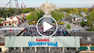 Overhead image of Strides for Mackenzie Health at Canada's Wonderland with a 'play' icon linking to a video from Strides for Mackenzie Health