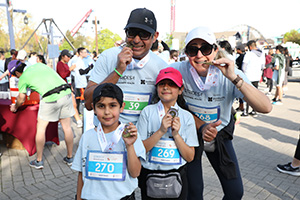 A family celebrates with their medals after crossing the finish line at the 19th annual Strides for Mackenzie Health. 